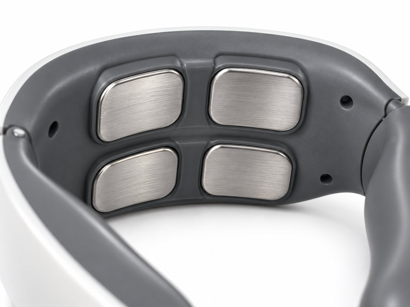 Macro view of the four flat brushed-metal contact pads inside the collar's back band